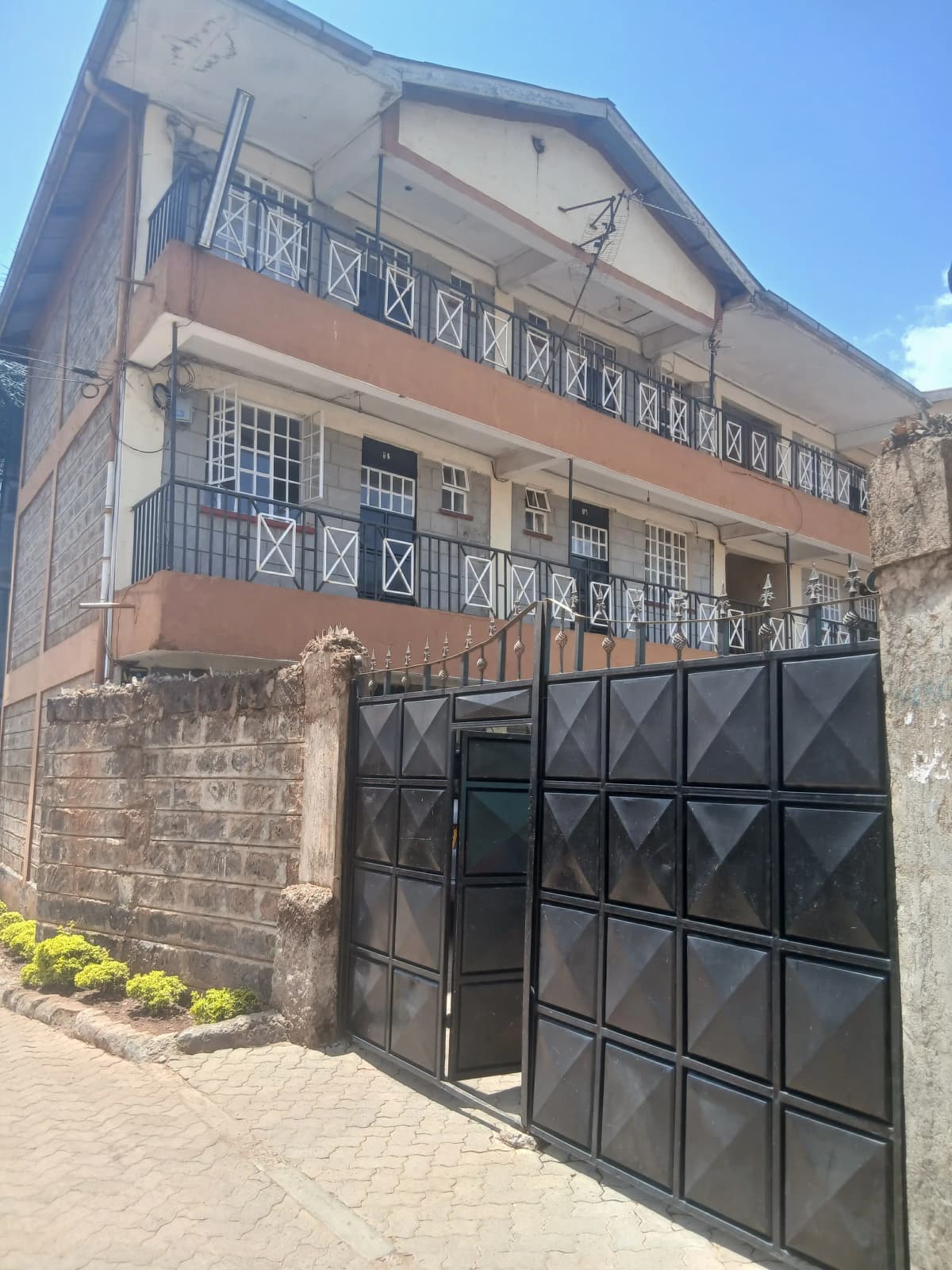 Multi-story residential building with black metal gate entrance
