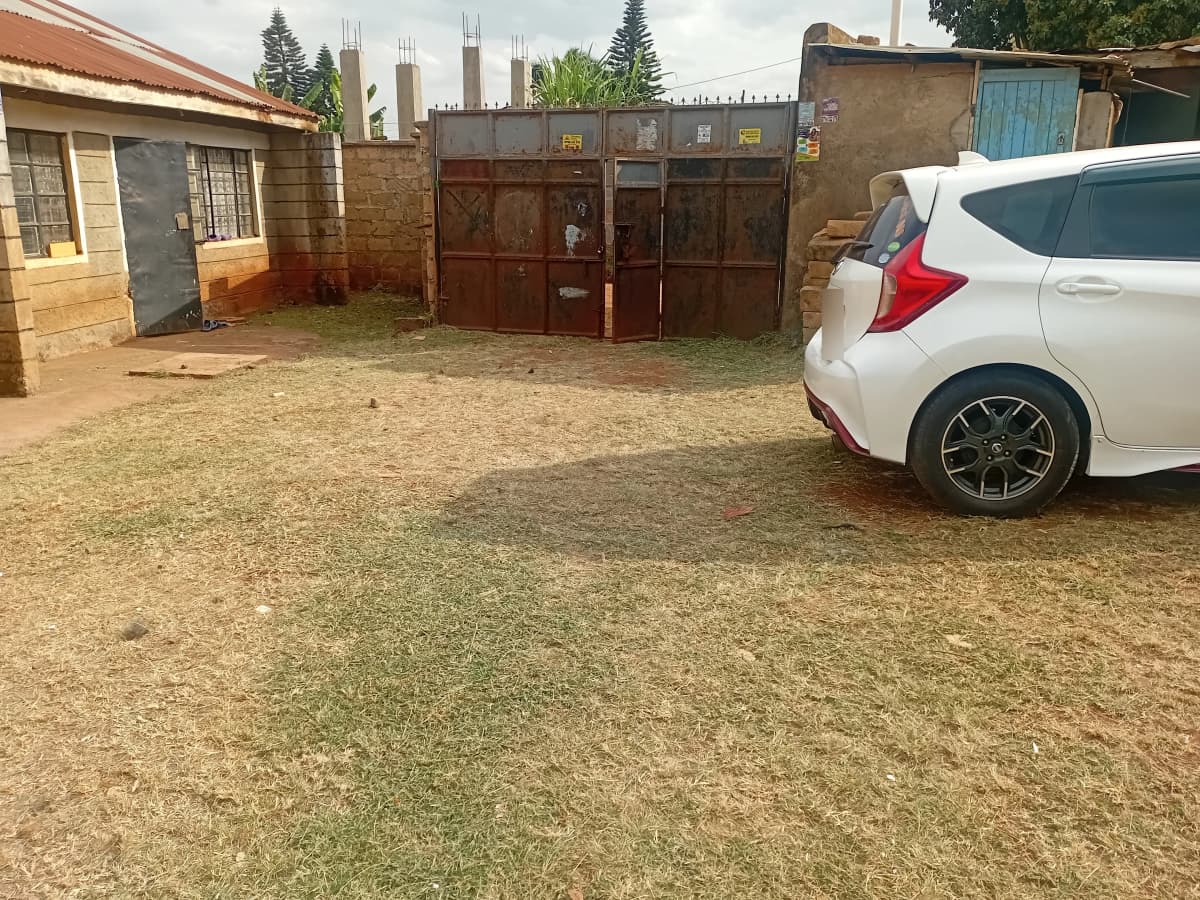 Compound entrance with parked vehicle and metal gate