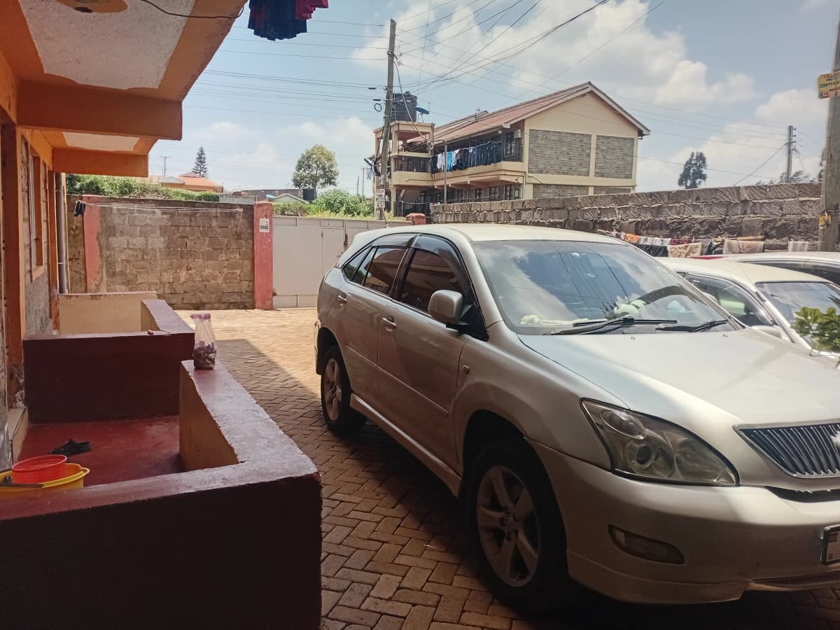 Paved compound parking area with vehicle and gate entrance