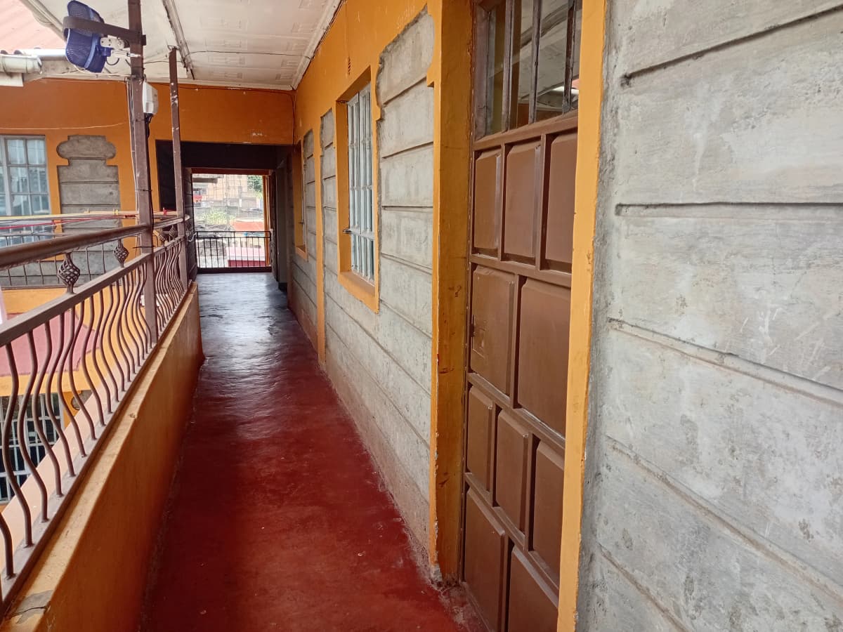Long corridor with orange walls and red concrete flooring