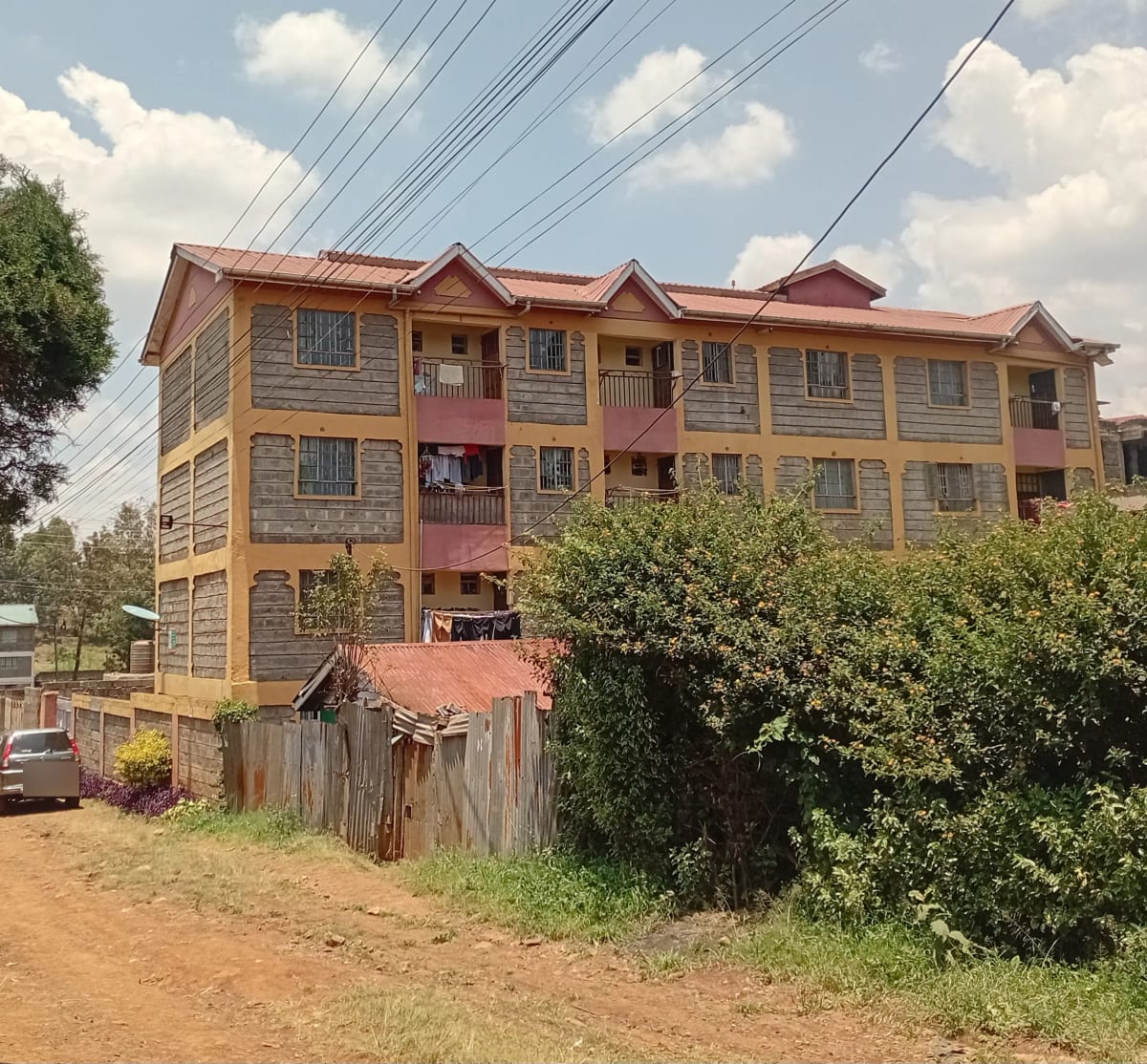 Three-story residential building with ochre facade and red roof
