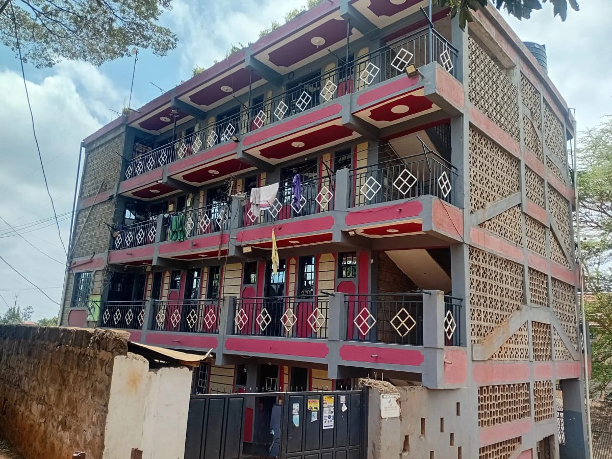 Multi-story residential building with decorative brick facade and red balconies