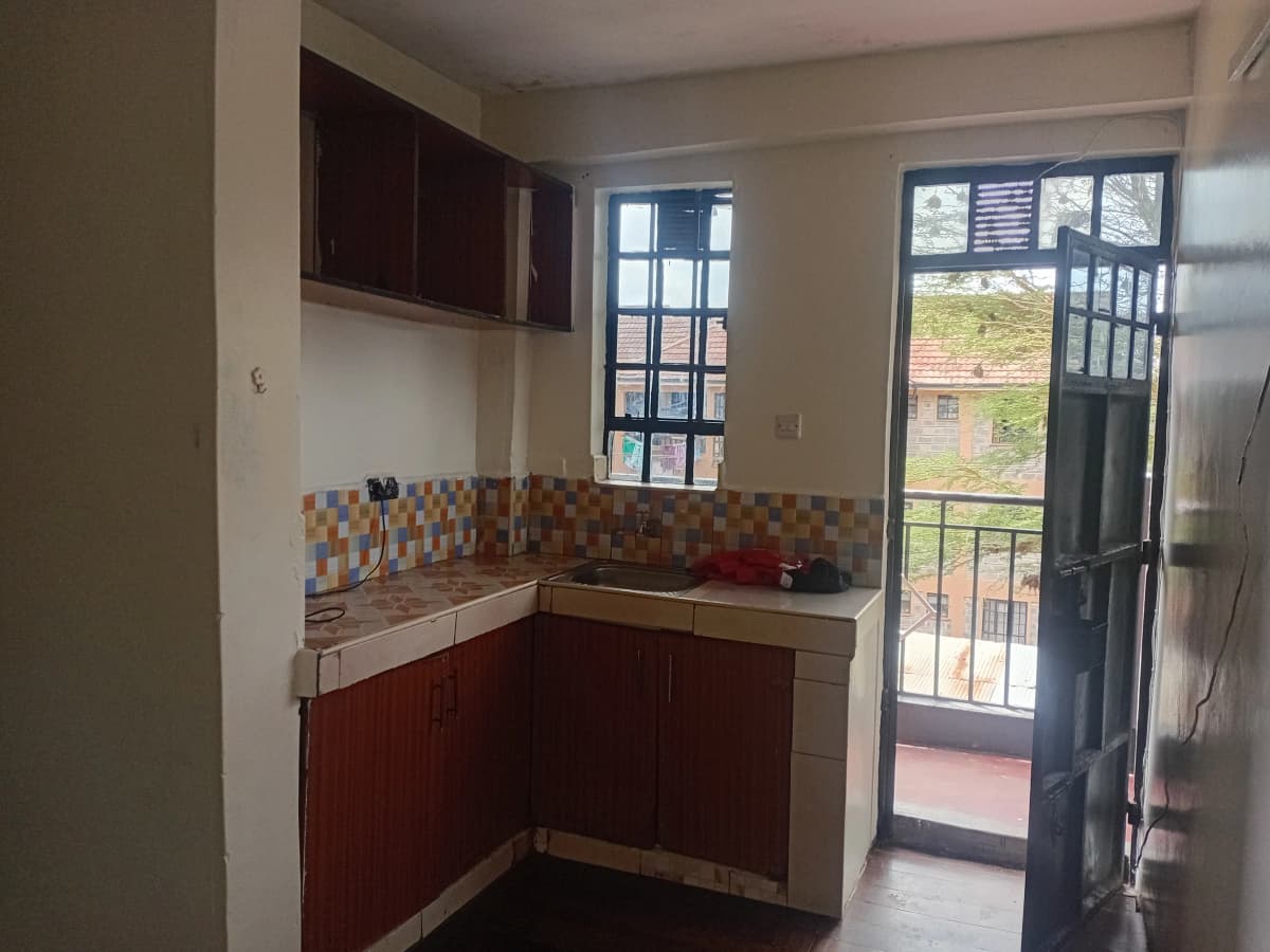 Compact kitchen with dark cabinetry and tiled backsplash