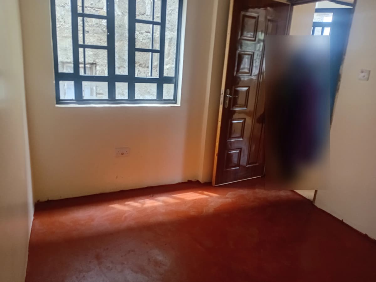 Empty bedroom with wooden door and bright window light