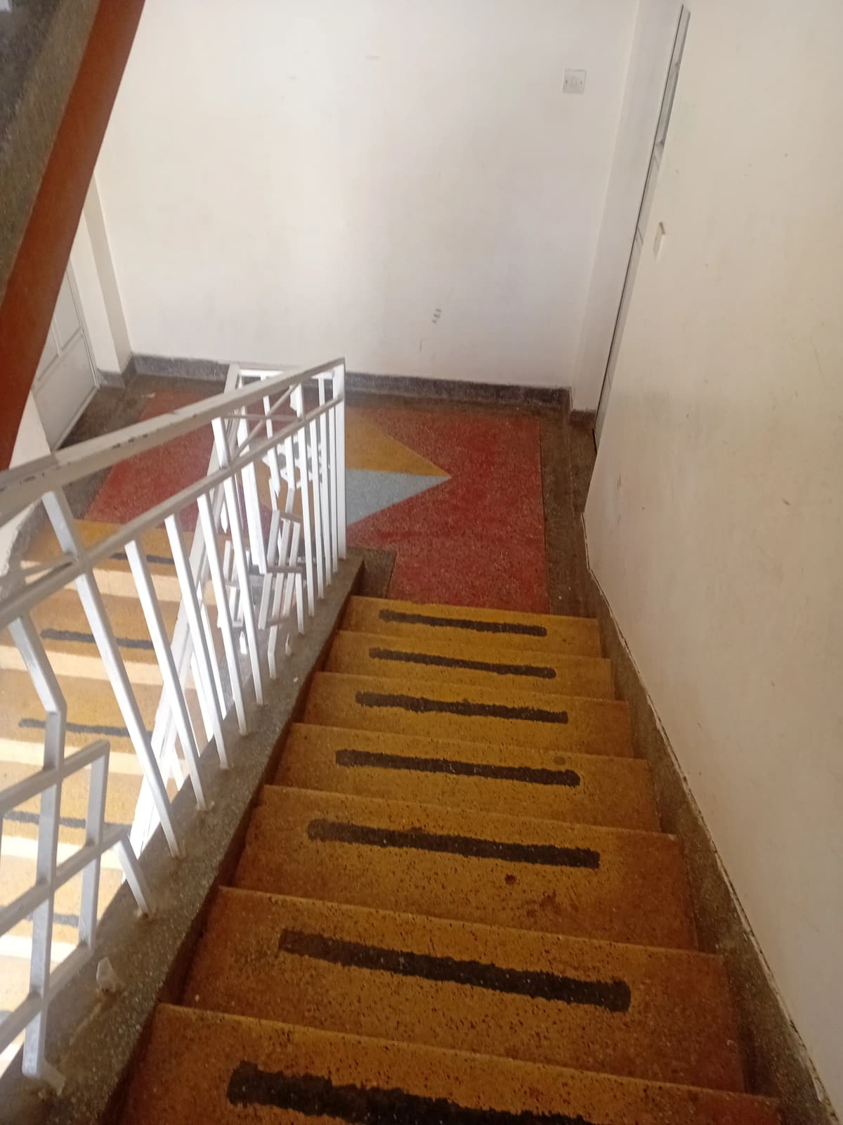 Interior staircase with white railing and wooden steps