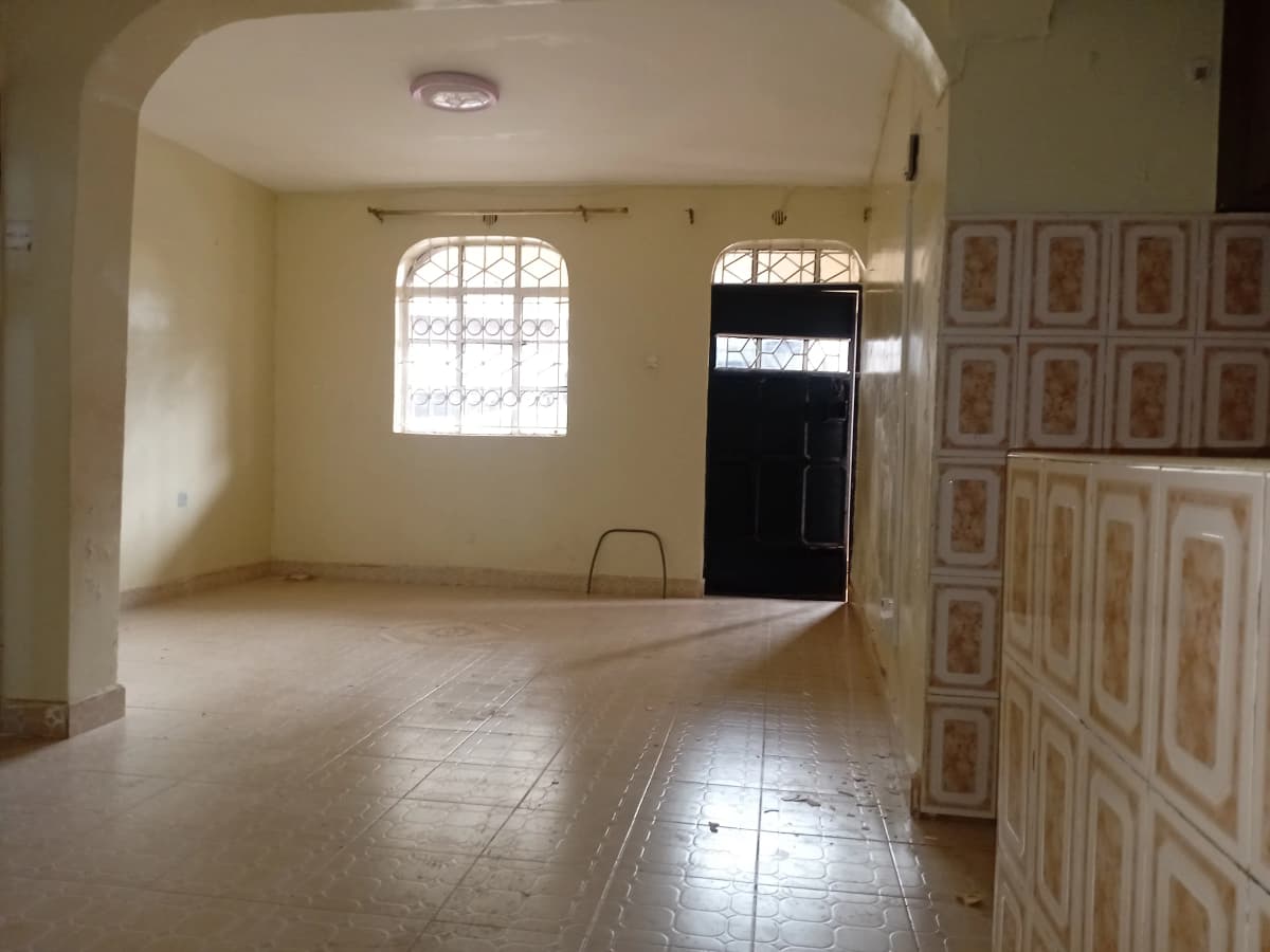 Empty living room with tiled floor and barred windows