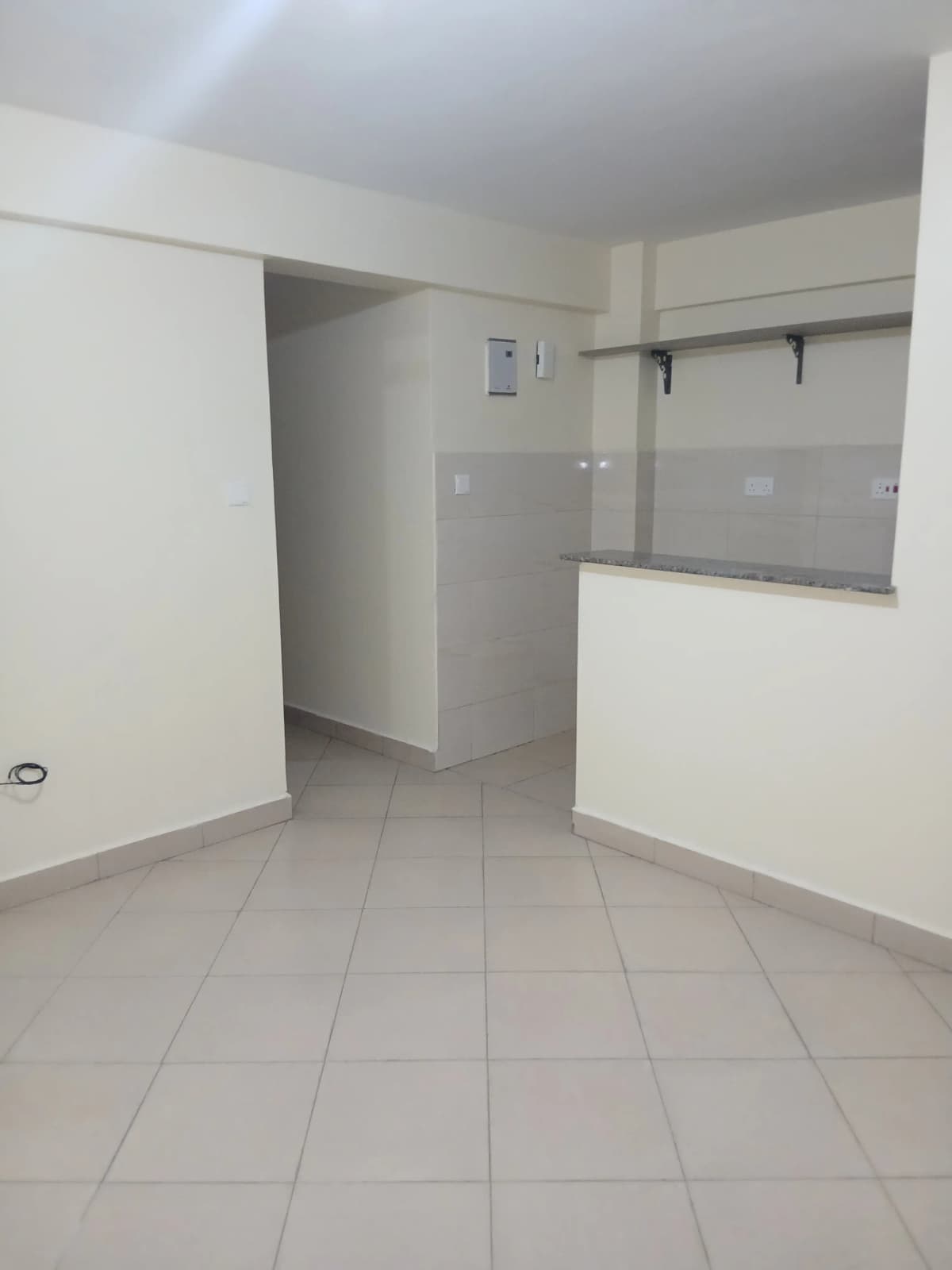 Open-plan kitchen with partial counter and tile flooring