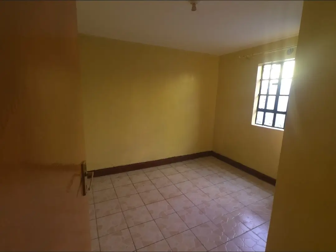 Empty bedroom with yellow walls and tiled flooring