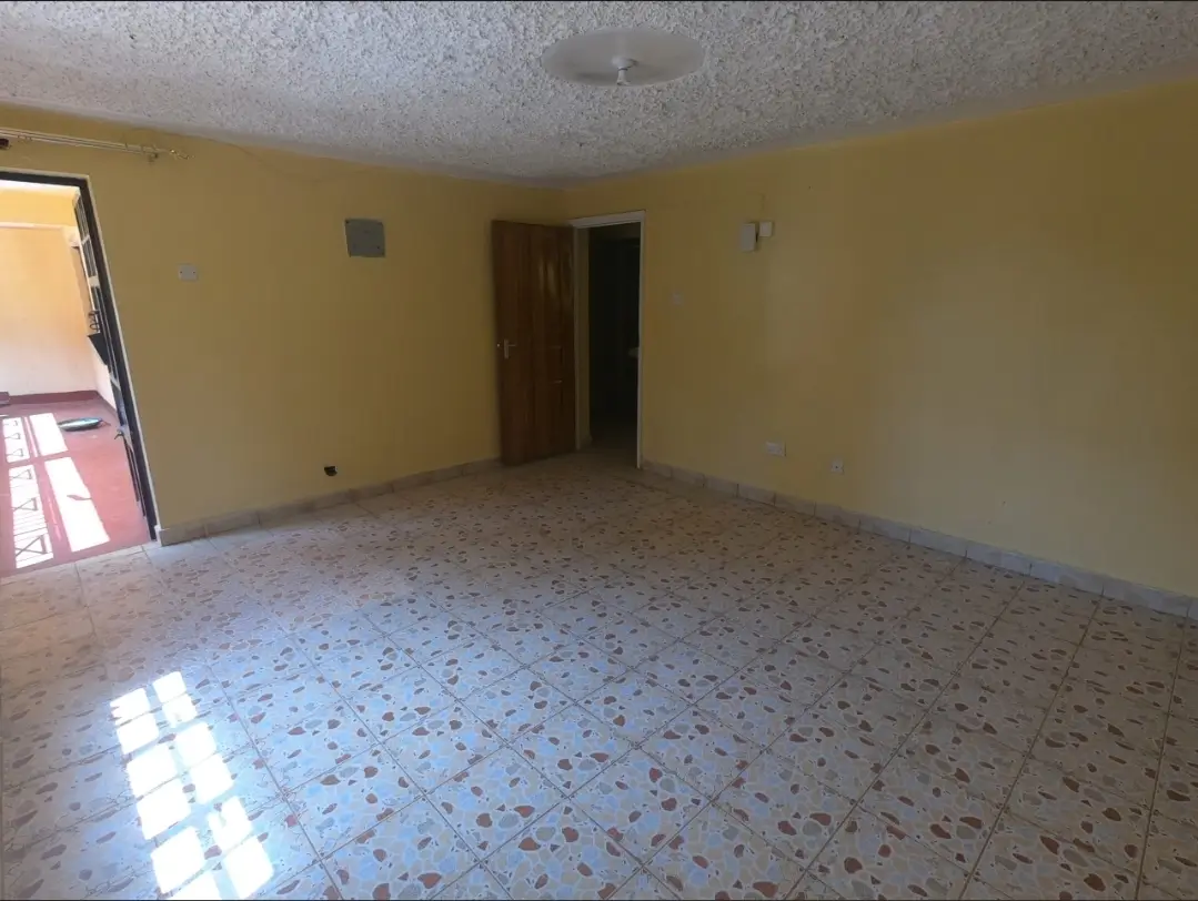Empty living room with terrazzo flooring and yellow walls