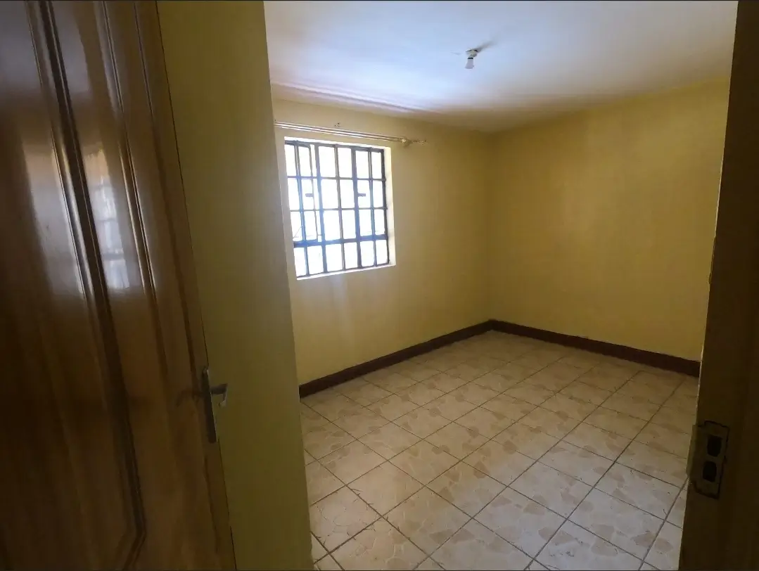 Empty bedroom with yellow walls and tiled flooring