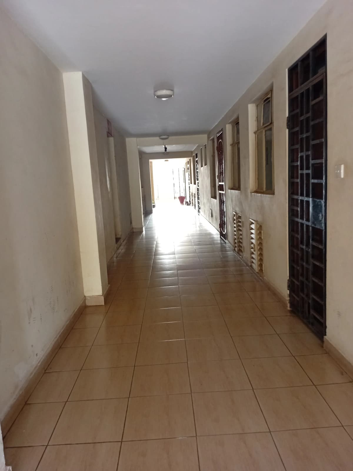 Long corridor with tiled floor and multiple doors