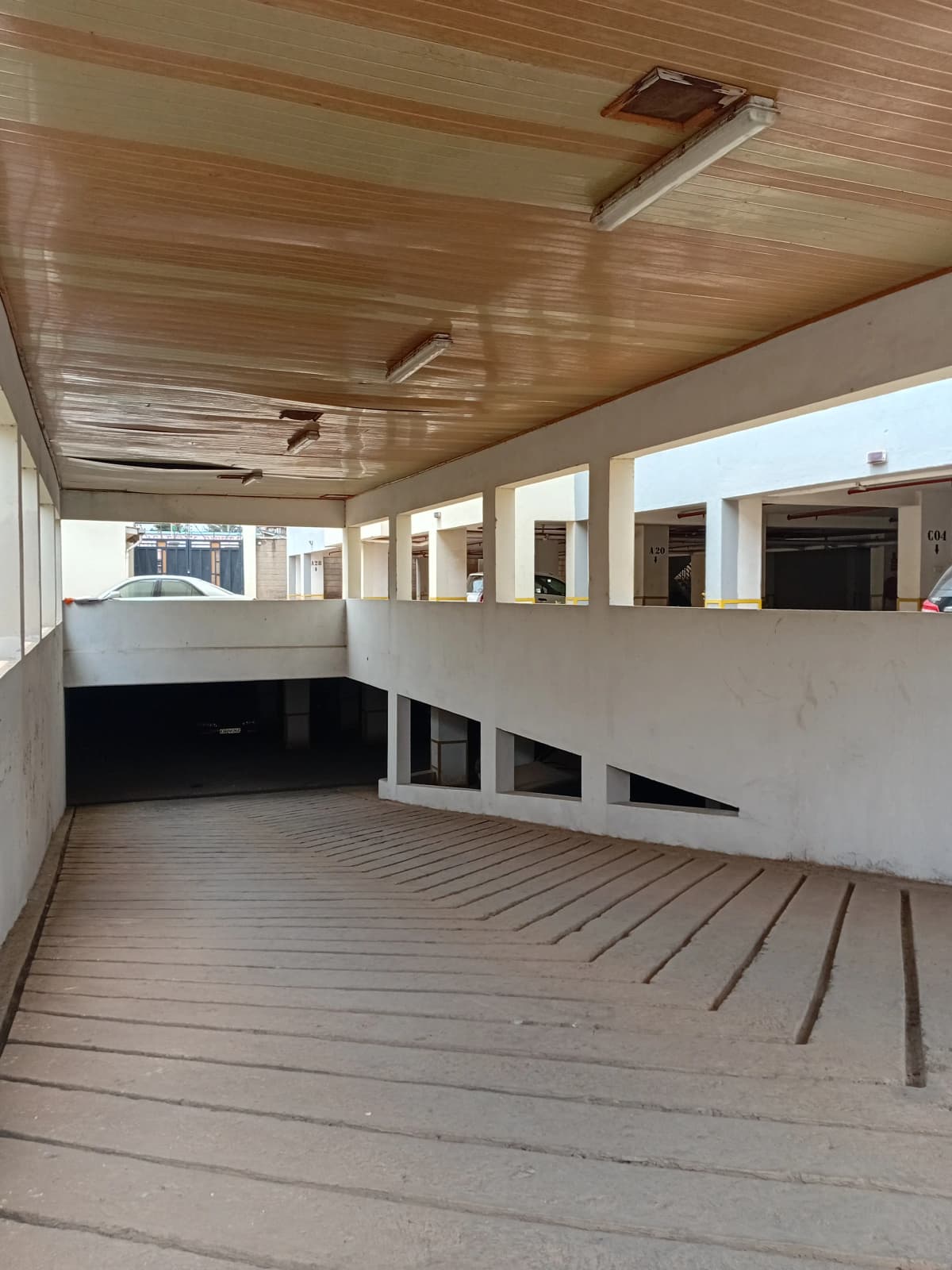 Covered wooden deck with glass railings and city views