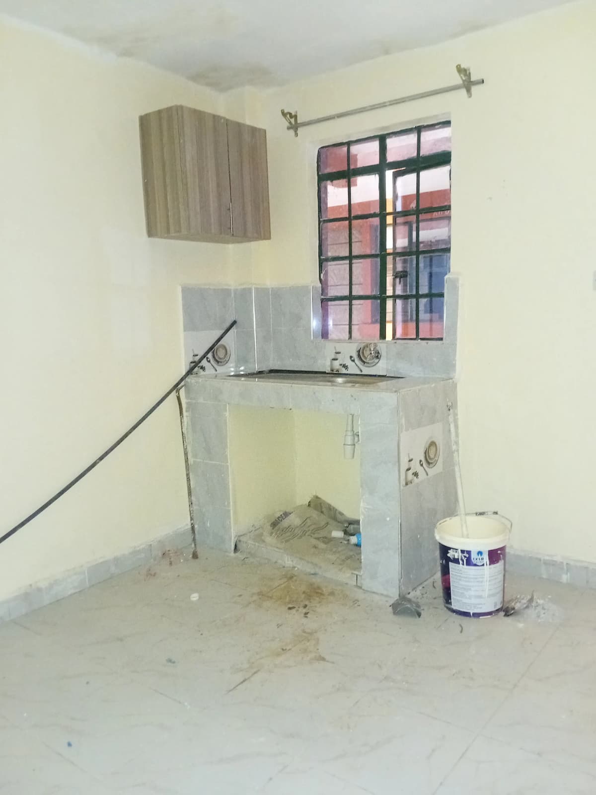 Under-construction kitchen with basic cabinetry and sink installation