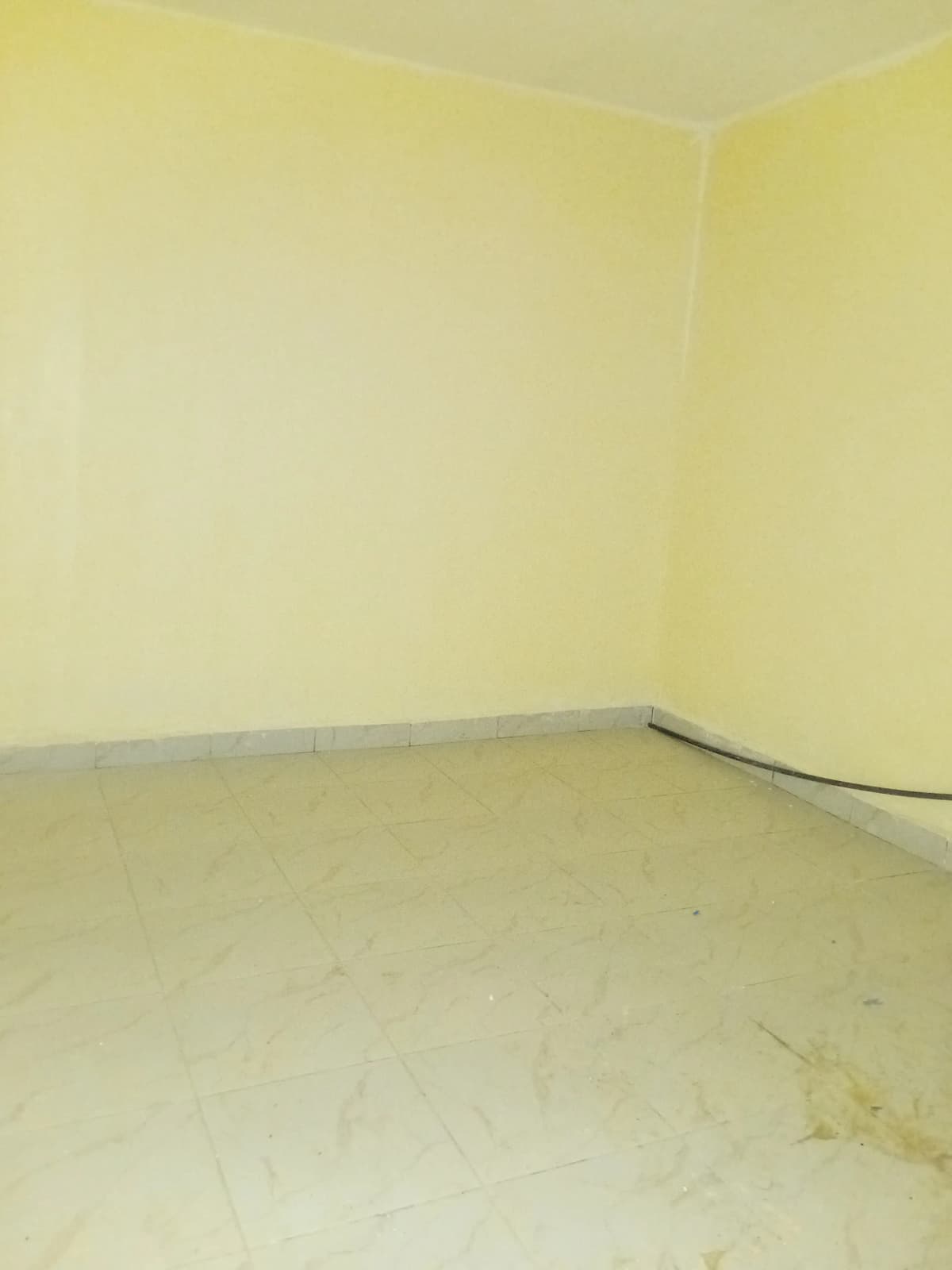 Empty room with yellow walls, possibly under renovation