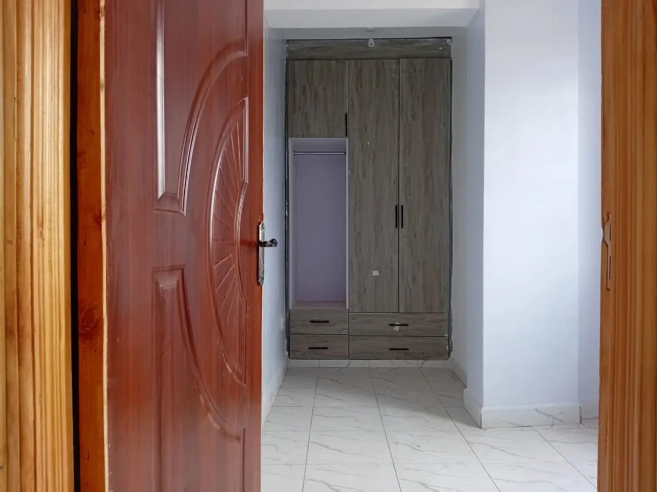 Corridor with red entrance door and built-in wardrobe