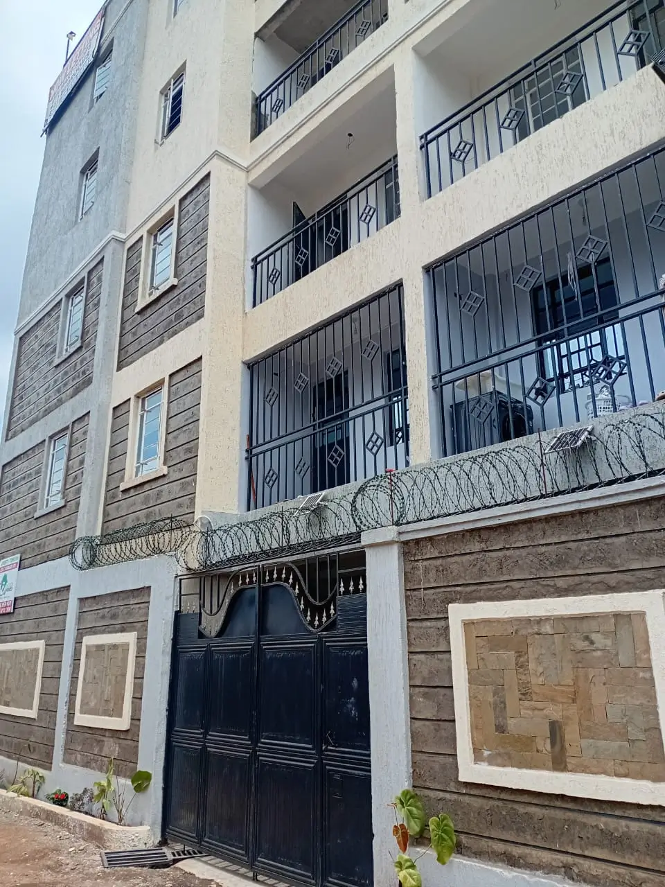 Multi-story apartment building facade with black gates and barred windows