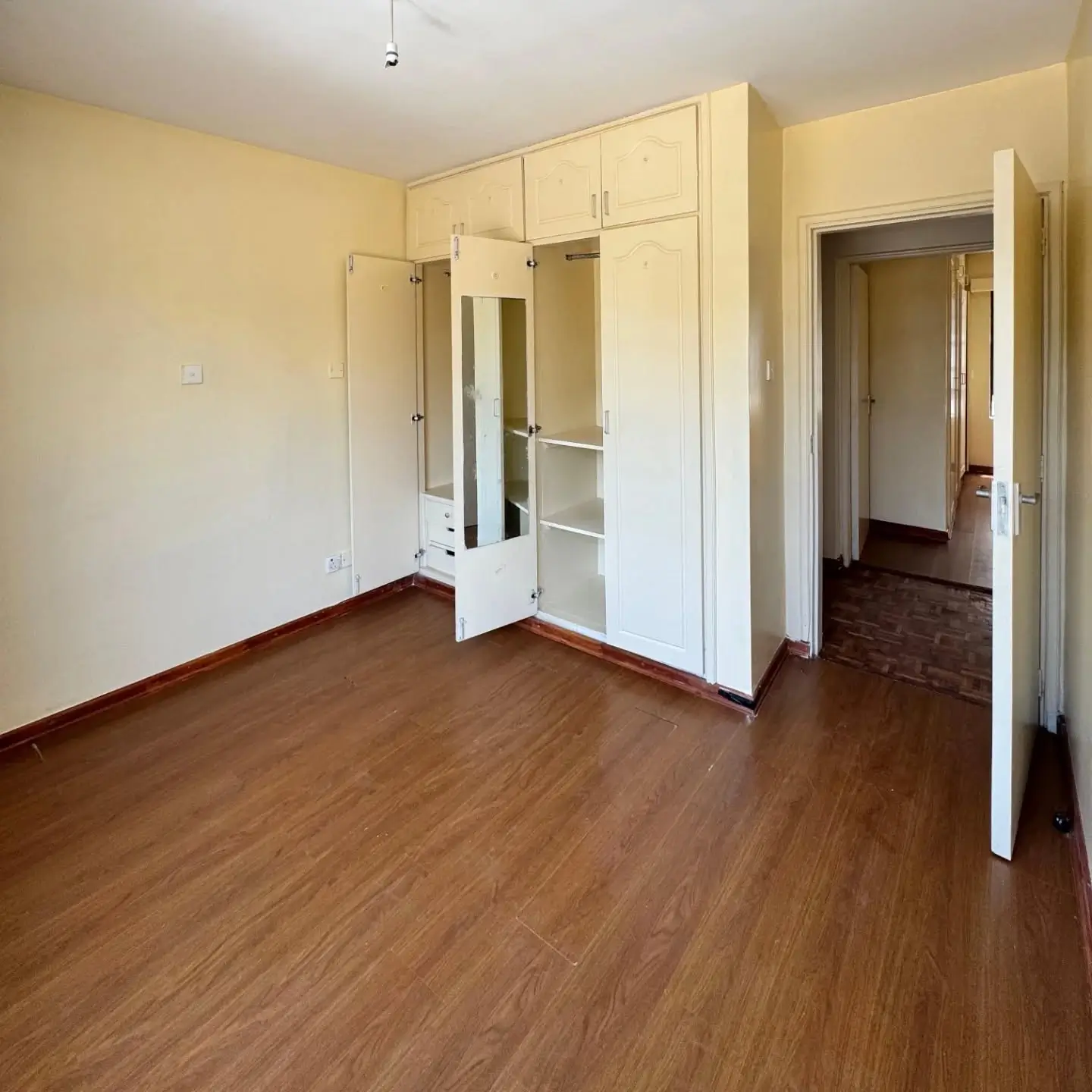 Spacious bedroom with built-in wardrobe and wooden flooring