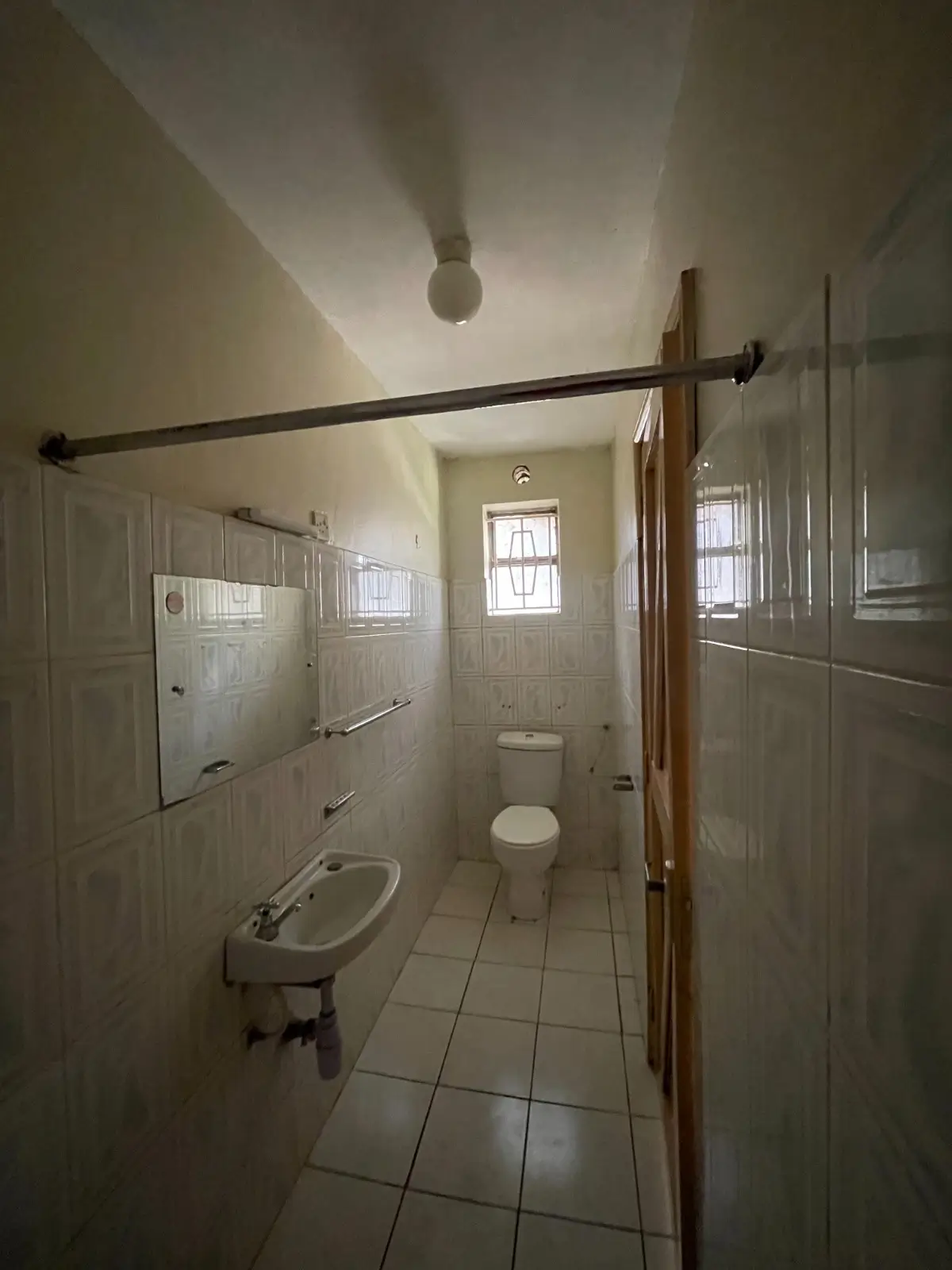 Narrow bathroom with pedestal sink and toilet