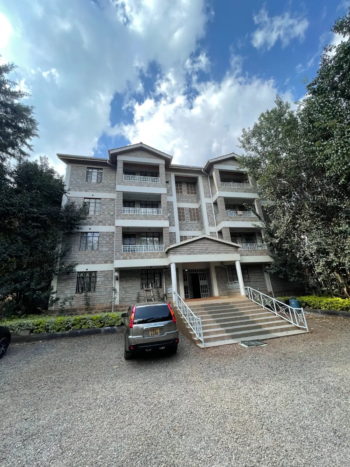 Modern multi-story apartment building with manicured compound grounds