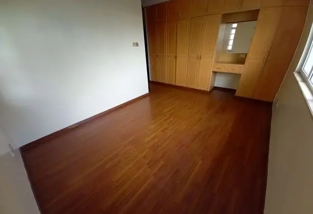 Spacious bedroom with wooden flooring and built-in wardrobe