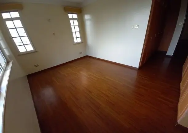Spacious living room with polished wooden floors and natural light