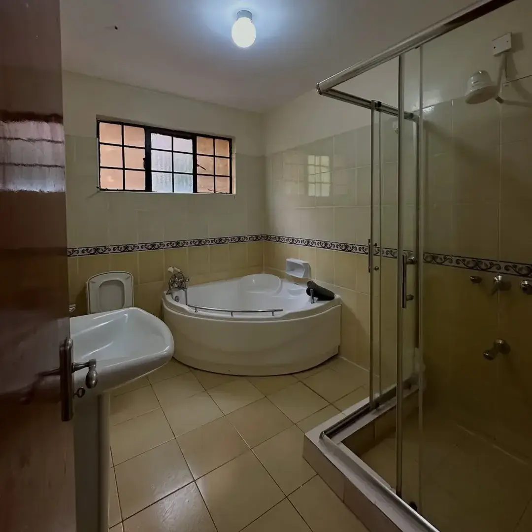 Spacious bathroom with corner bathtub and glass shower enclosure