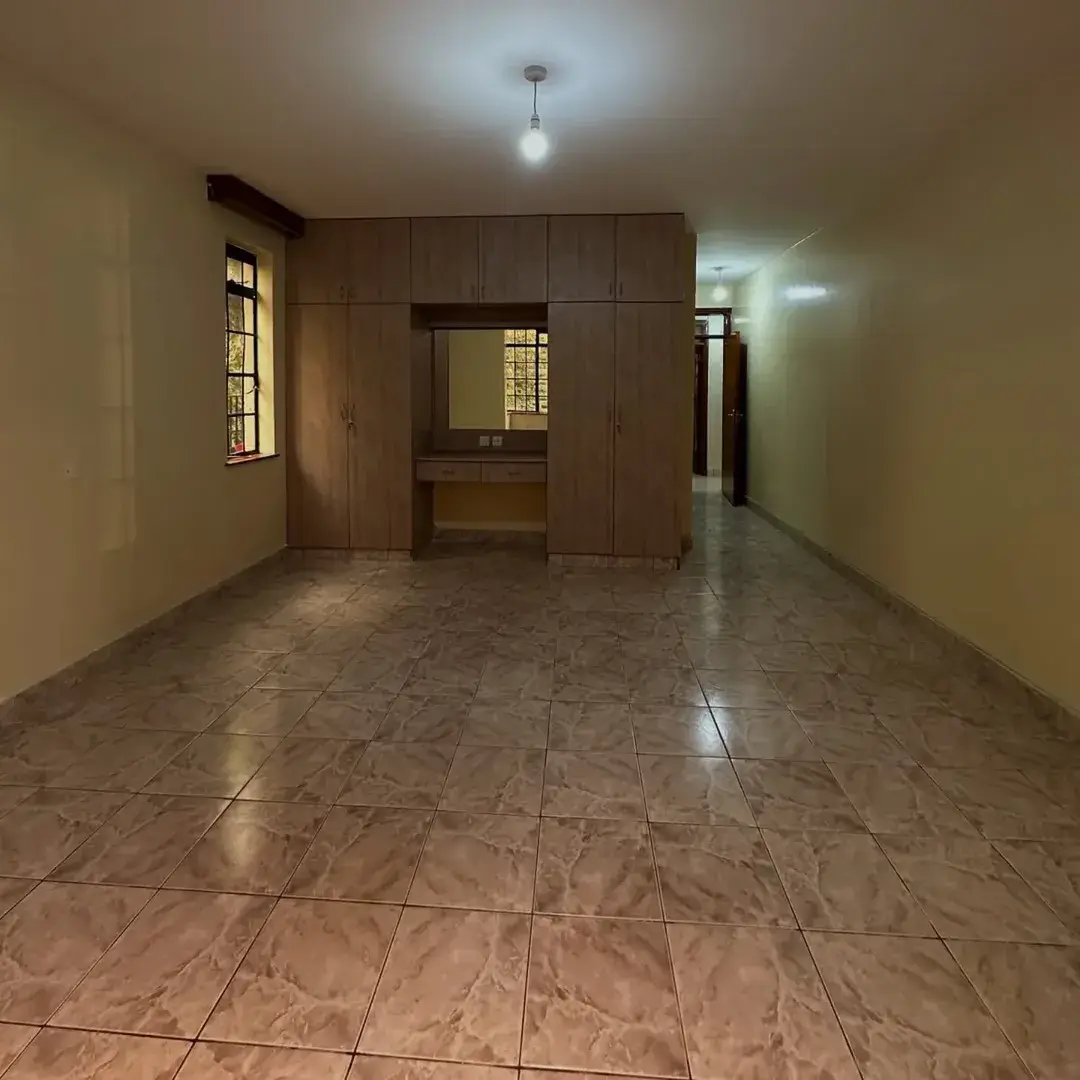 Spacious empty living room with tiled flooring and natural light