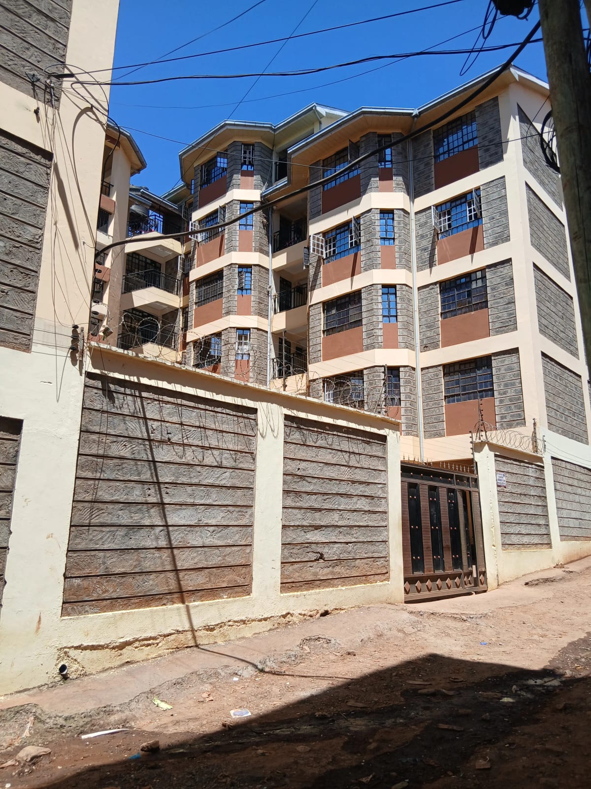 Multi-story residential building with perimeter wall and gate