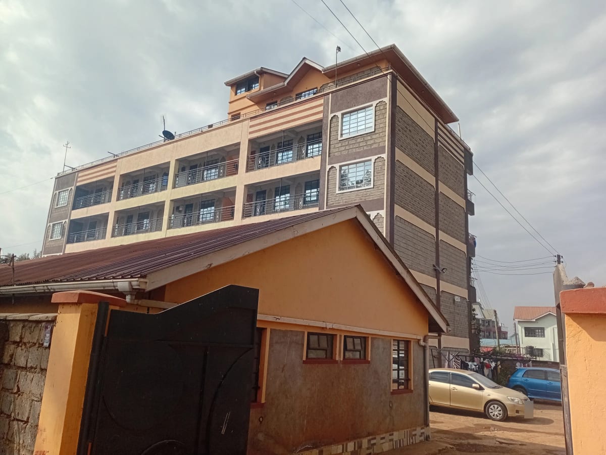 Multi-story residential building with brown facade and street view