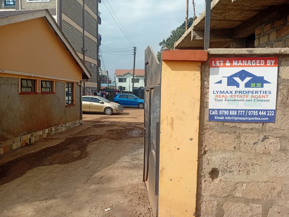 Property compound entrance with yellow walls and metal gate