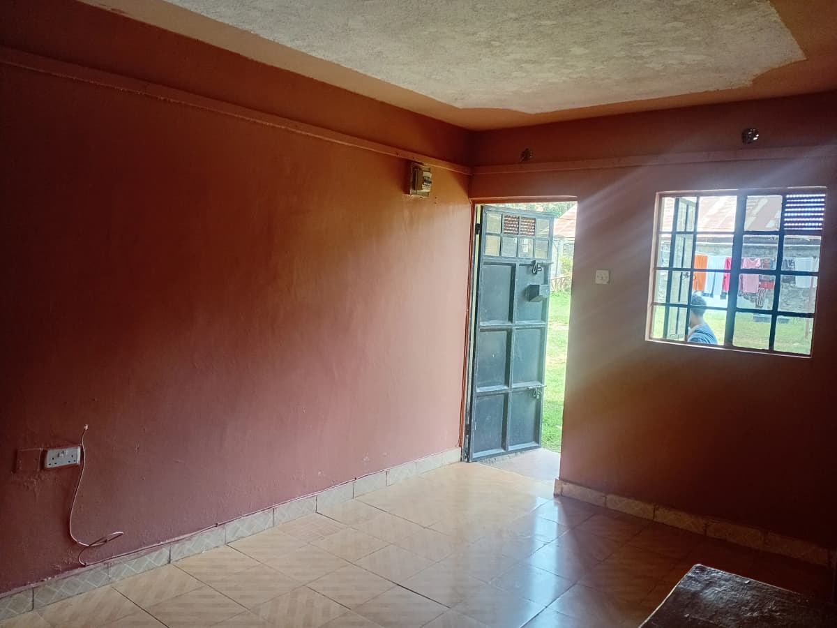 Empty living room with terracotta walls and tiled floor