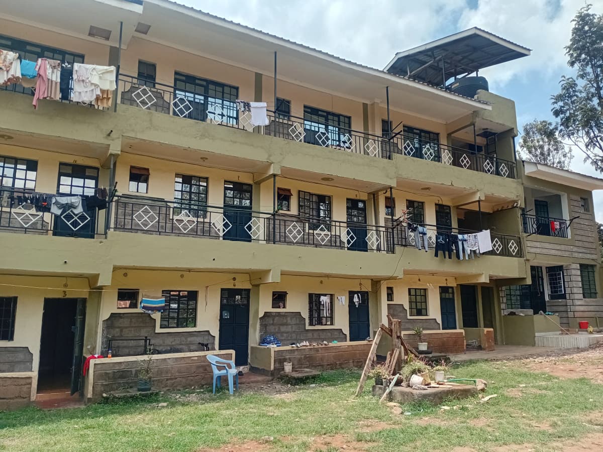 Three-story residential building with balconies and ground compound