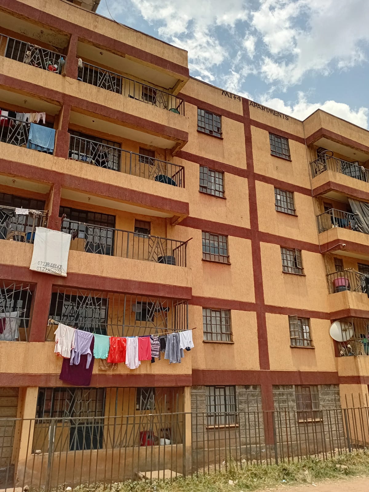 Multi-story residential building with balconies and security grilles
