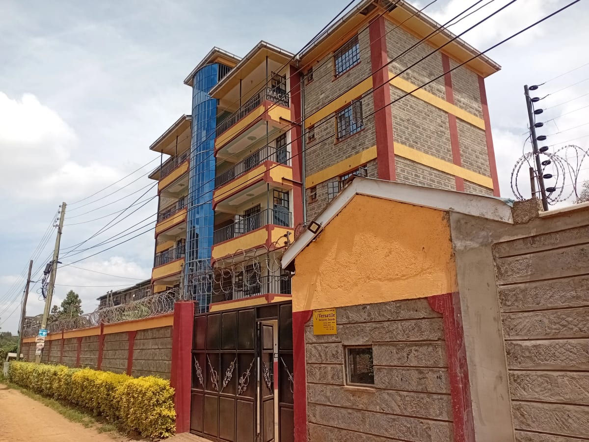 Multi-story residential building with colorful facade and compound gate