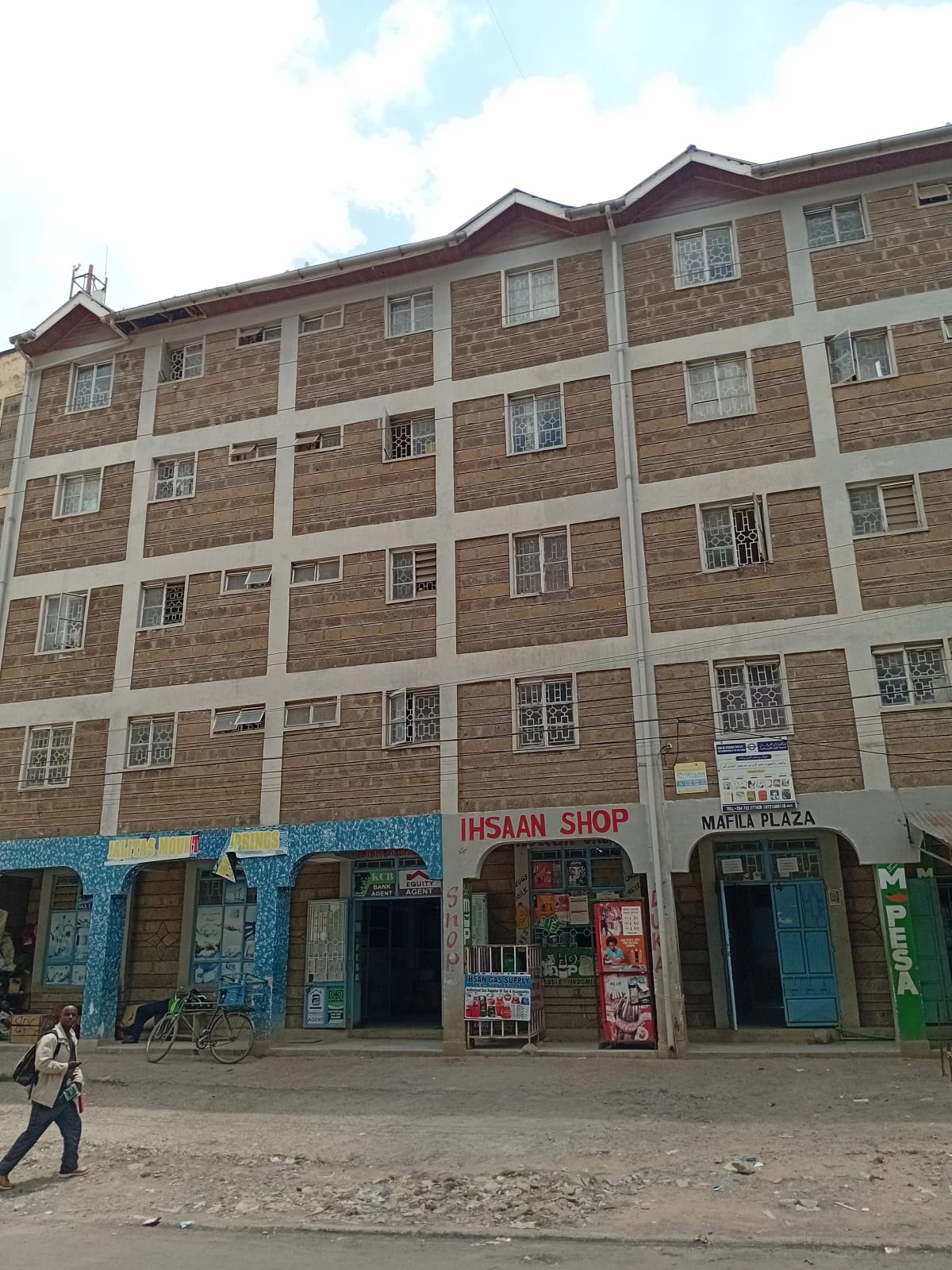 Multi-story residential building with ground-floor retail shops