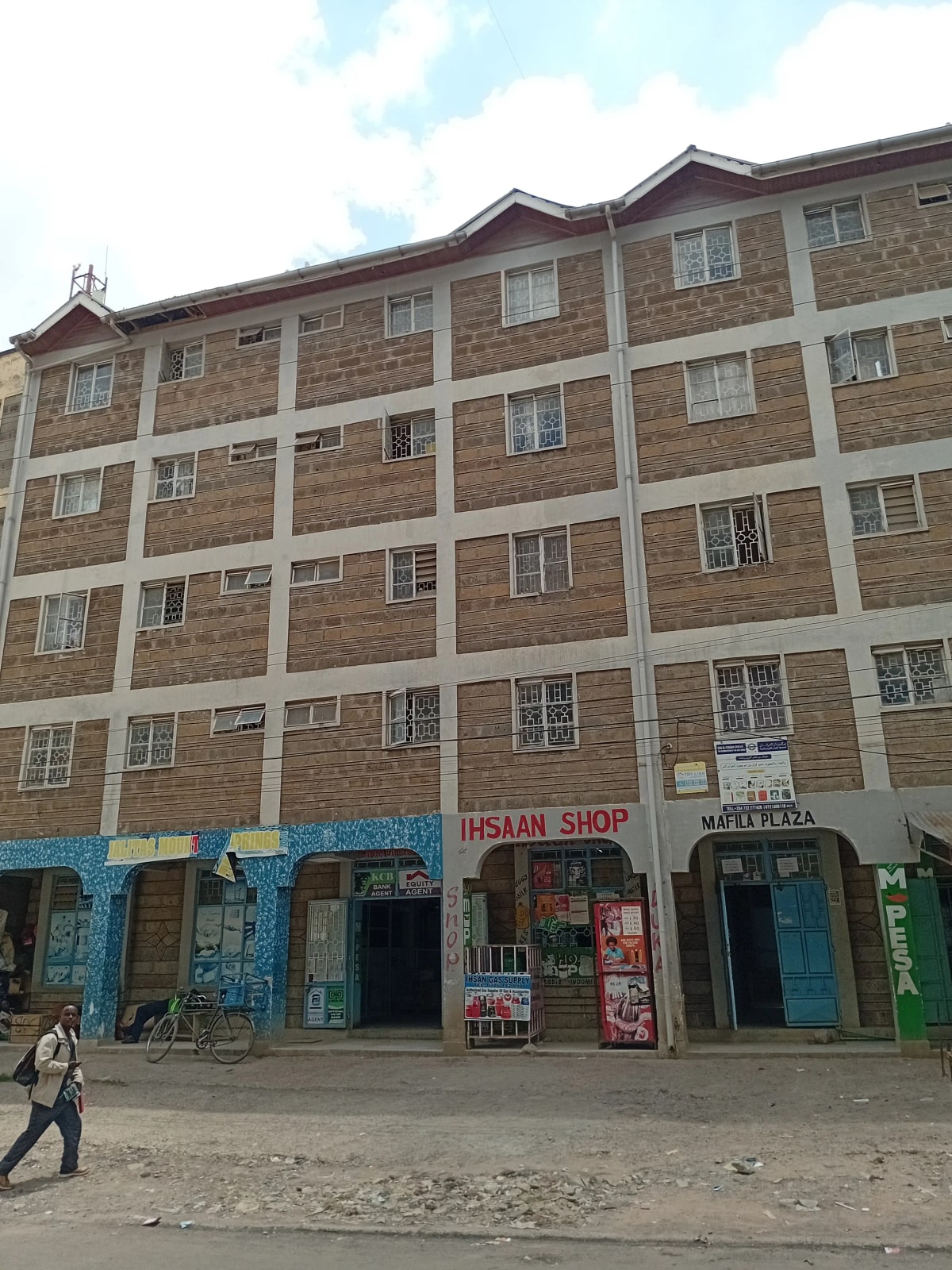 Multi-story residential building with ground-floor retail shops