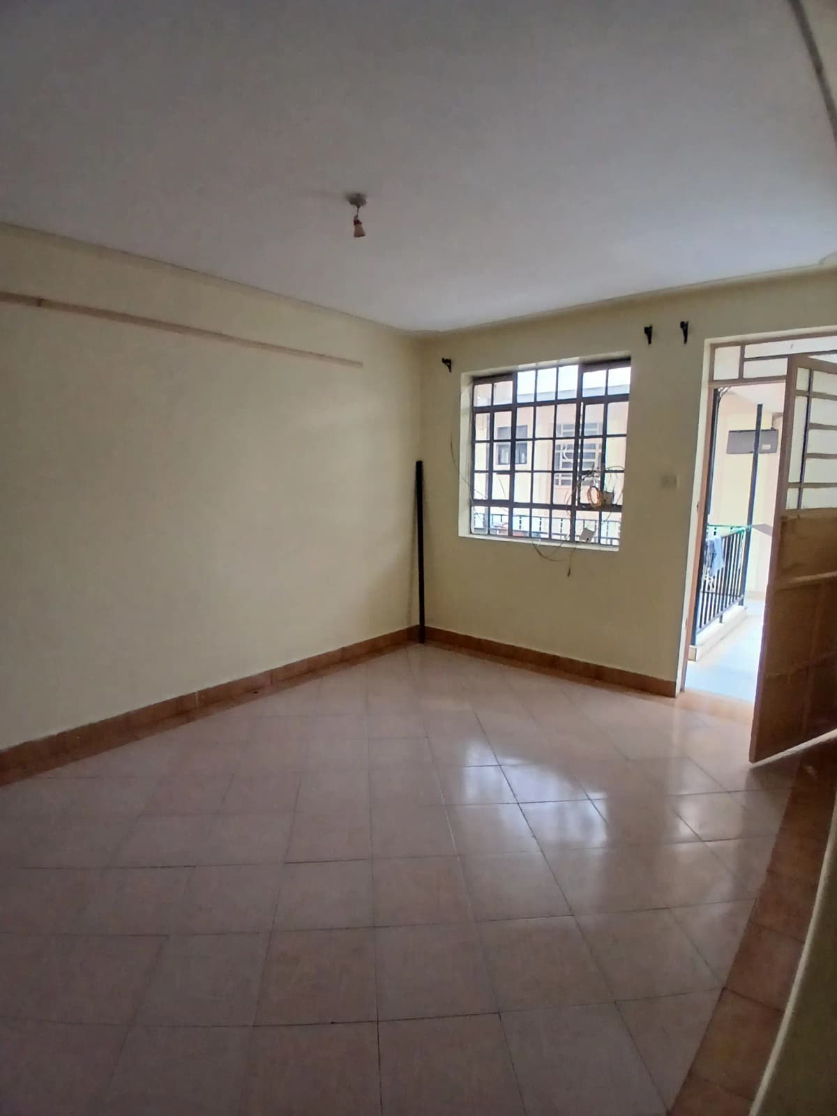 Spacious empty living room with tiled floor and natural light