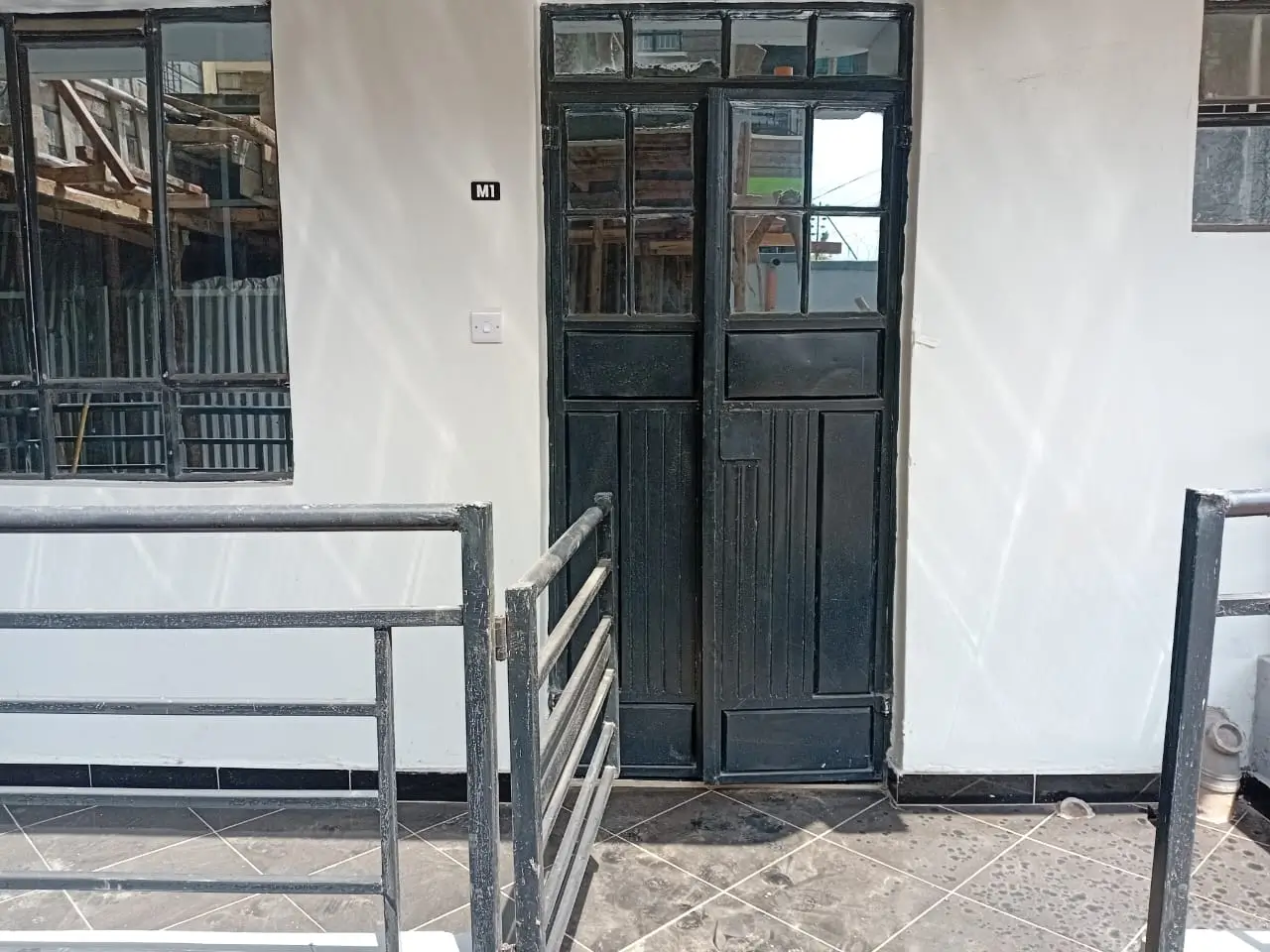Building entrance with dark wooden double doors and metal railings