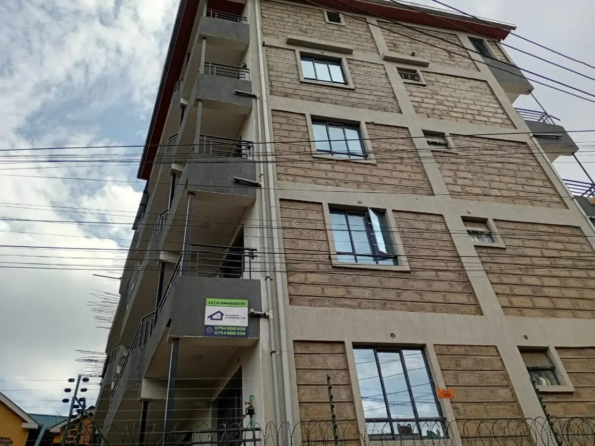 Multi-story residential building facade with balconies and brick finish