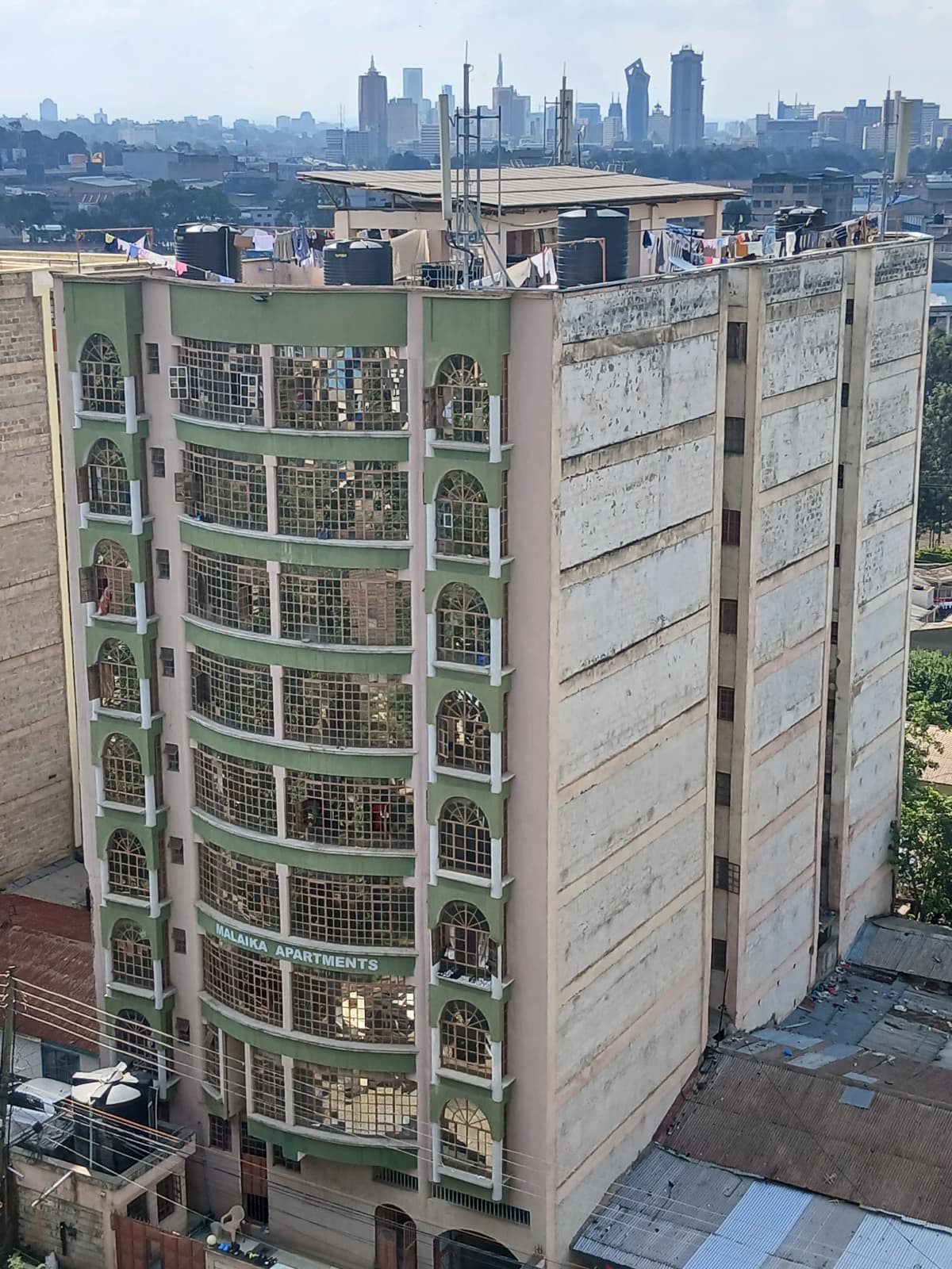 Multi-story residential building with city skyline backdrop