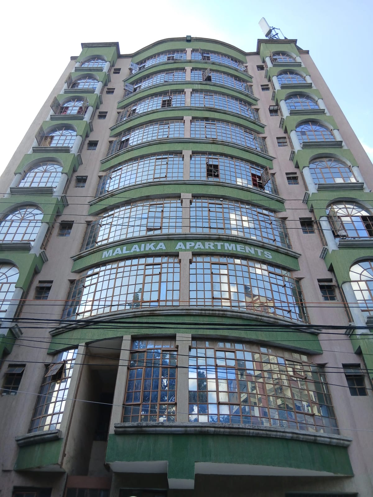 Curved art deco apartment building facade with green trim