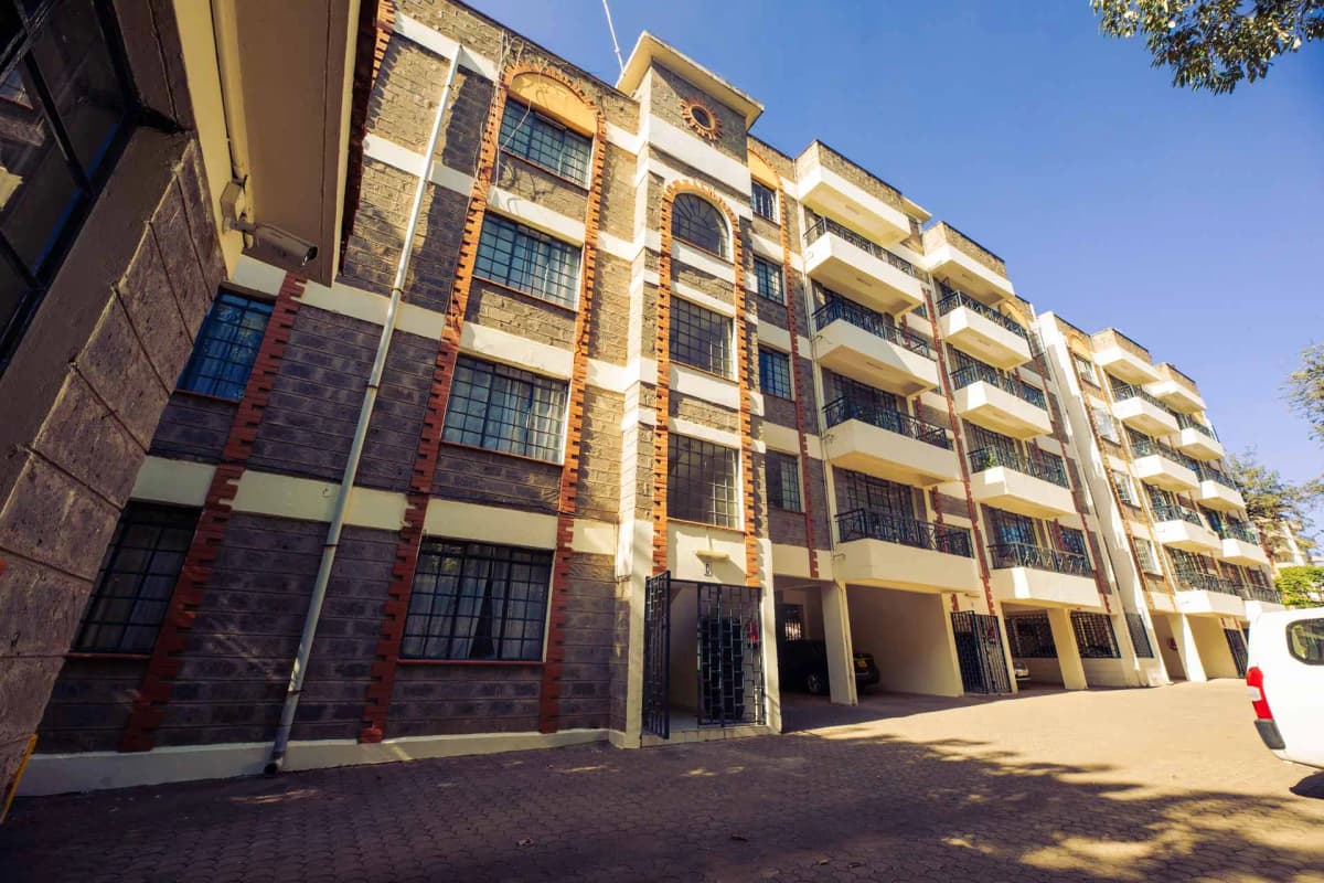 Modern multi-story residential building with yellow facade and balconies