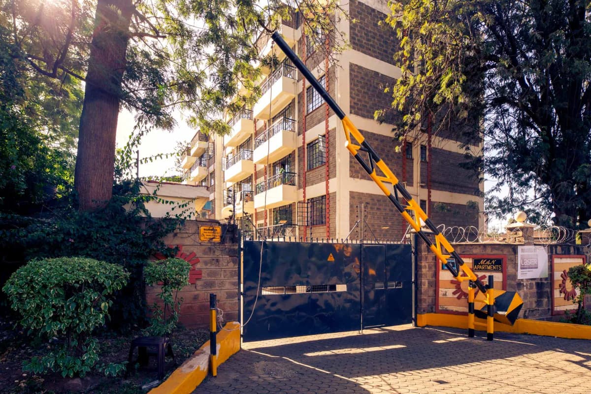 Multi-story residential building with security gate and landscaping