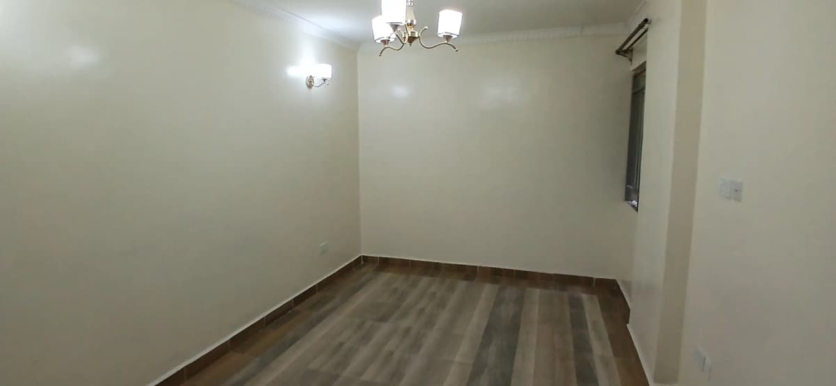 Empty bedroom with laminate flooring and ceiling fixtures