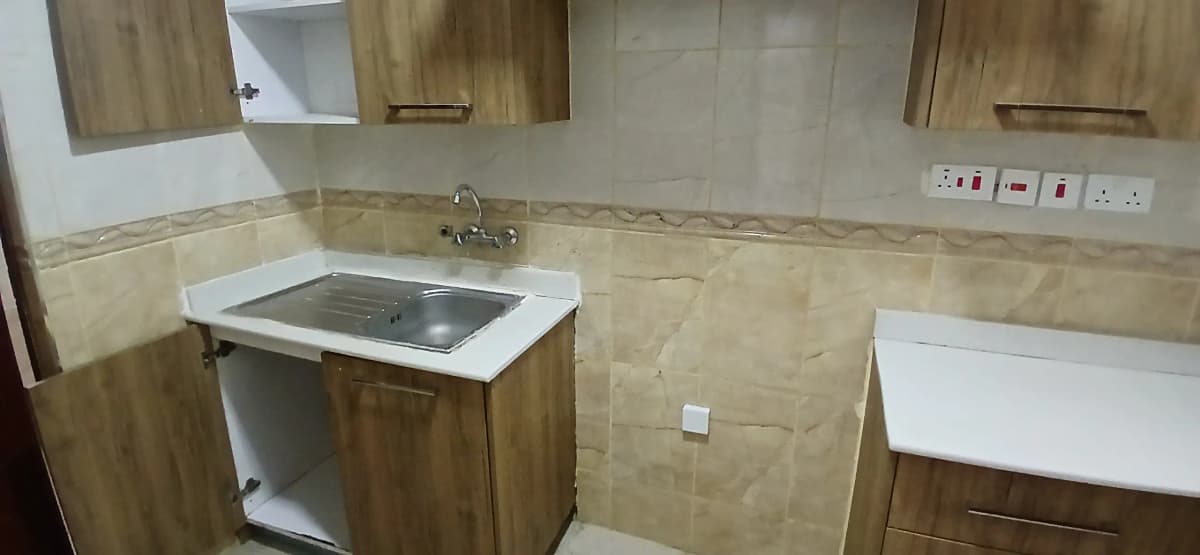 Compact kitchen with induction cooktop and wooden cabinetry