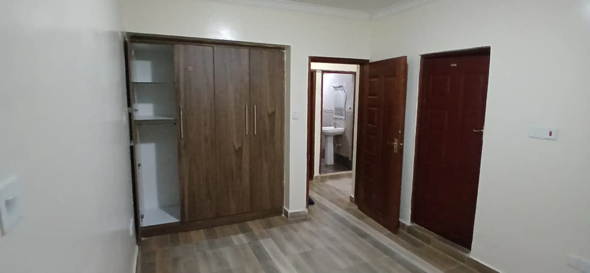 Spacious bedroom with built-in wardrobe and wooden doors
