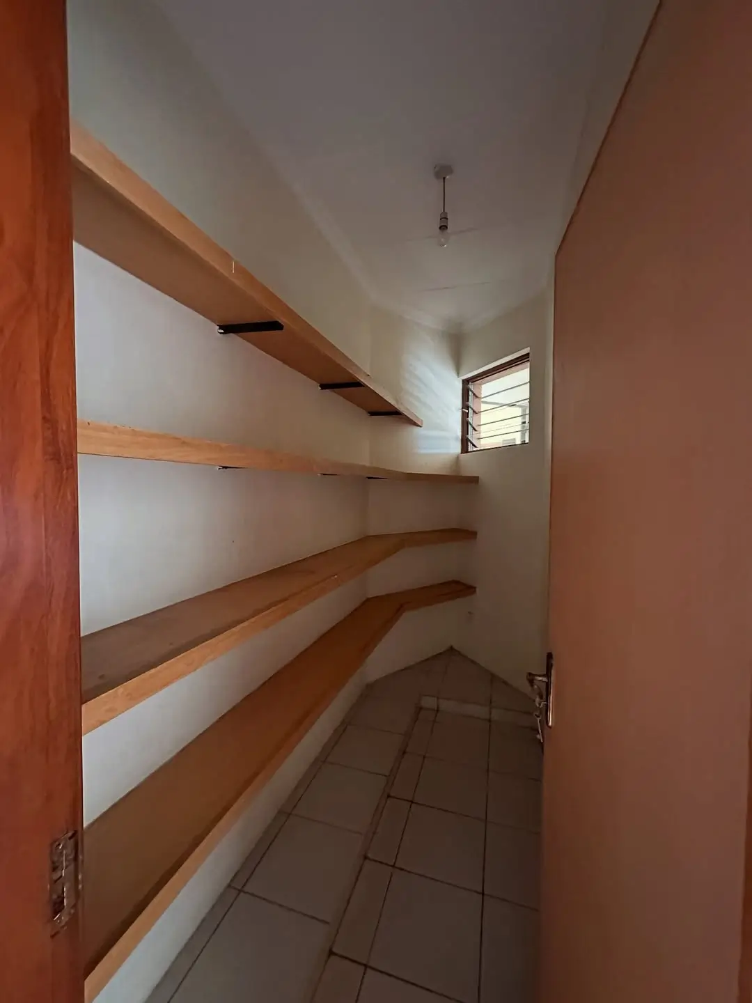 Wooden shelving storage room with tiled floor