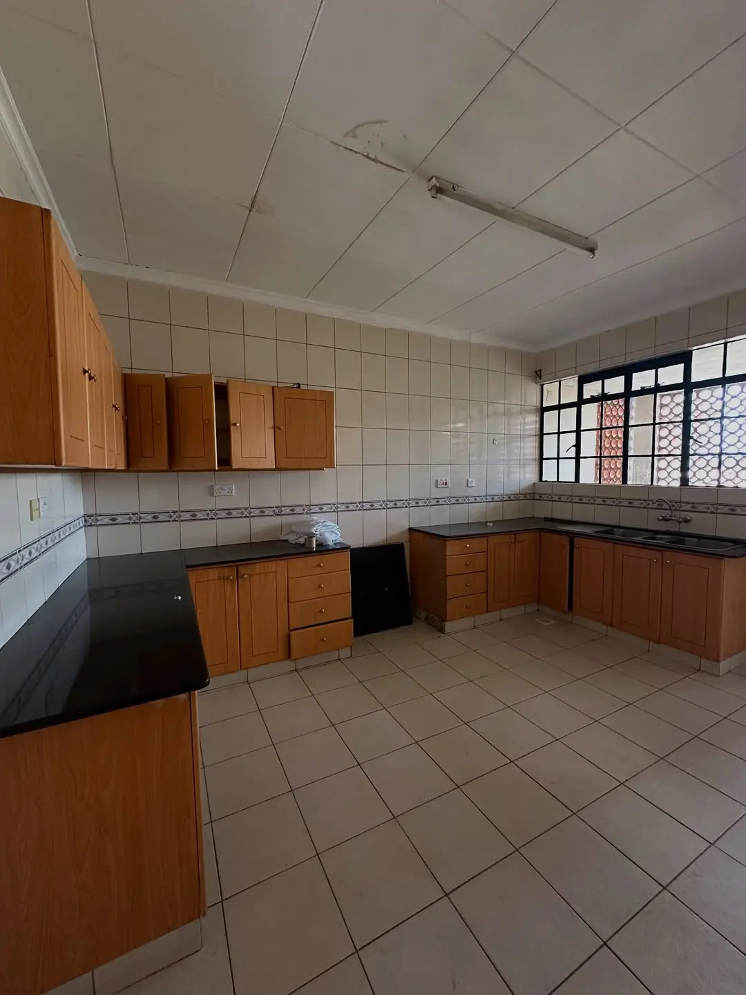 Spacious kitchen with wooden cabinets and tiled flooring