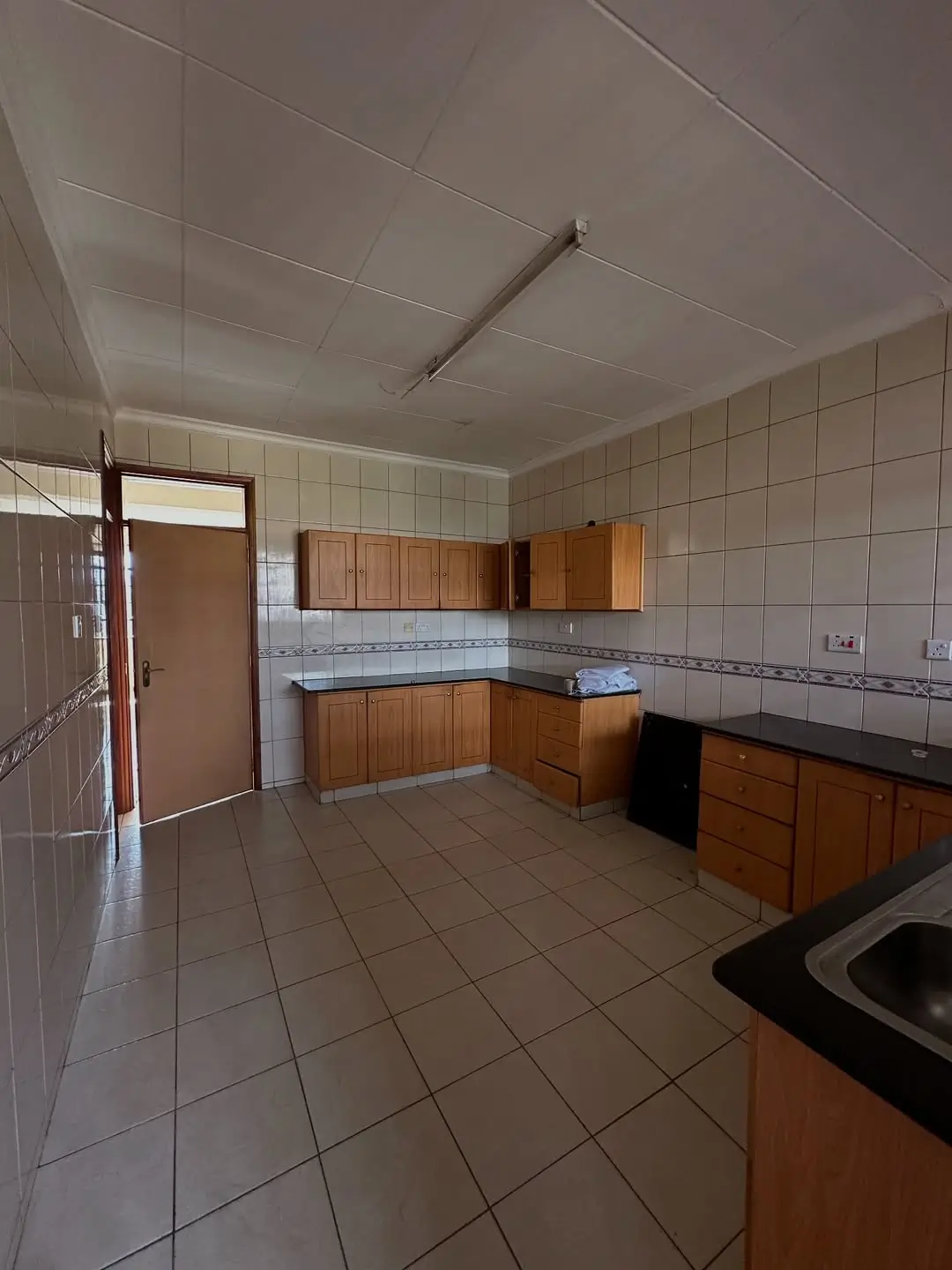 Spacious kitchen with wooden cabinets and tiled countertops