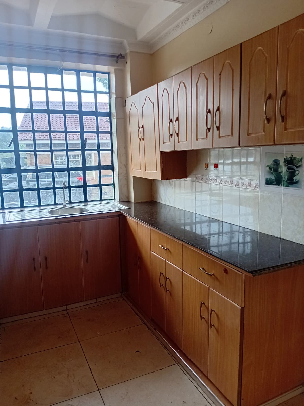 Compact kitchen with wooden cabinetry and dark countertops
